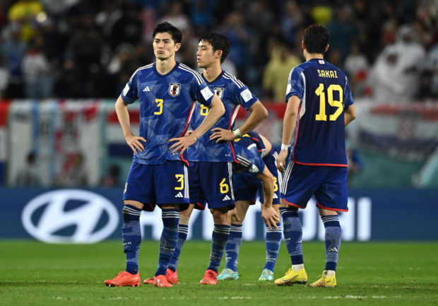 Soccer Football - FIFA World Cup Qatar 2022 - Round of 16 - Japan v Croatia - Al Janoub Stadium, Al Wakrah, Qatar - December 5, 2022 Japan's Shogo Taniguchi, Wataru Endo and teammates look dejected after losing the penalty shootout as Japan are eliminated from the World Cup