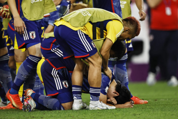 Soccer Football - FIFA World Cup Qatar 2022 - Round of 16 - Japan v Croatia - Al Janoub Stadium, Al Wakrah, Qatar - December 5, 2022  Japan's Yuto Nagatomo looks dejected with teammates after the penalty shootout as Japan are eliminated from the World Cup