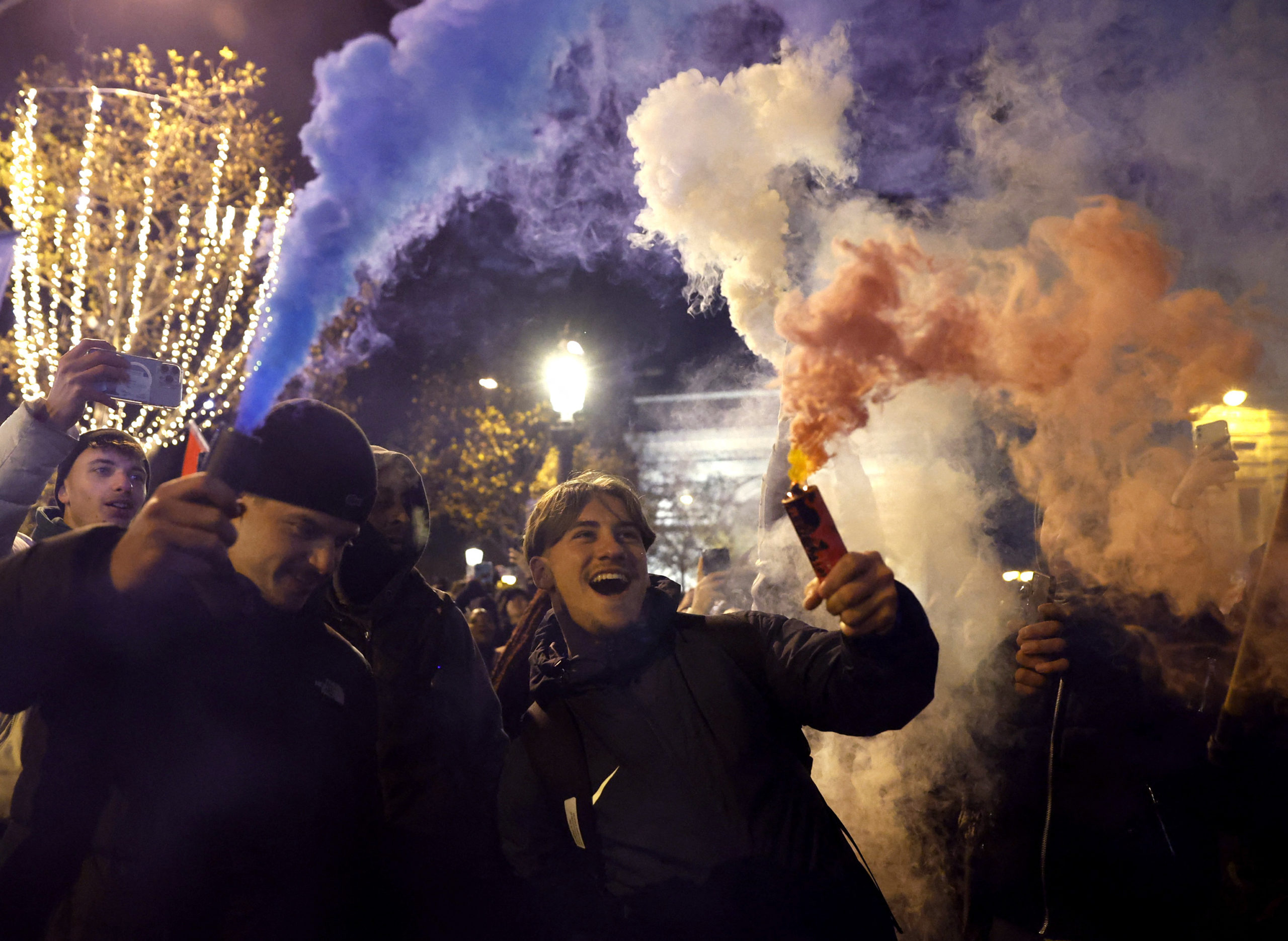 Soccer Football - FIFA World Cup Qatar 2022 - Fans gather in Paris for France v Morocco - Paris, France - December 14, 2022 France fans celebrate with flares on the Champs-Elysees after the match as France progress to the final