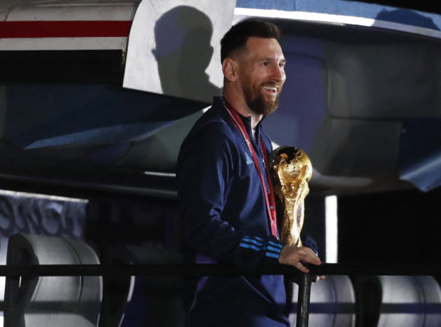 Football Soccer - Argentina team arrives in Buenos Aires after winning the World Cup - Buenos Aires, Argentina - December 20, 2022 Lionel Messi of Argentina with the trophy as the team arrives at Ezeiza International Airport REUTERS/Agustin Marcarian