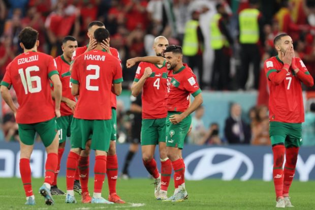 Morocco's players celebrate during the penalty shoot-out to win the Qatar 2022 World Cup round of 16 football match between Morocco and Spain at the Education City Stadium in Al-Rayyan, west of Doha on December 6, 2022. (Photo by KARIM JAAFAR / AFP)