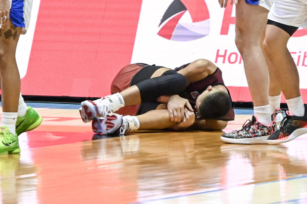Zavier Lucero holds on to his left knee after that fateful, no-contact fourth quarter play in Game 2. —UAAP MEDIA  