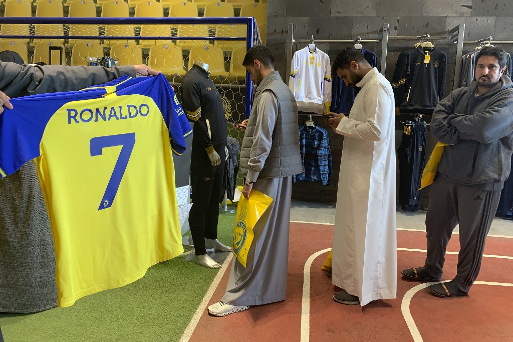 A fan holds t-shirt bearing the name Ronaldo and number 7, at the Saudi Al Nassr FC shop in the Saudi capital Riyadh, on December 31, 2022. - Cristiano Ronaldo on December 30 signed for Al Nassr of Saudi Arabia, the club announced, in a deal believed to be worth more than 200 million euros. The 37-year-old penned a contract which will take him to June 2025