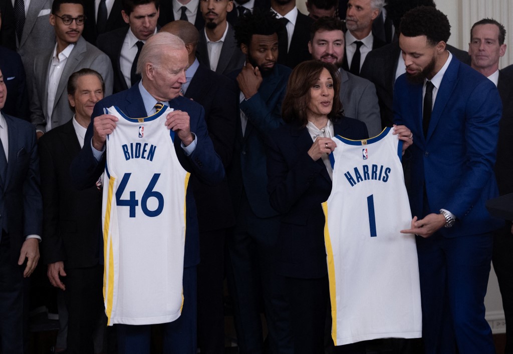 El presidente de EE. UU., Joe Biden, y la vicepresidenta de EE. UU., Kamala Harris, reciben camisetas de miembros del equipo de baloncesto Golden State Warriors durante una celebración por su campeonato de la NBA de 2022, en el Salón Este de la Casa Blanca en Washington, DC, el 17 de enero de 2023. .