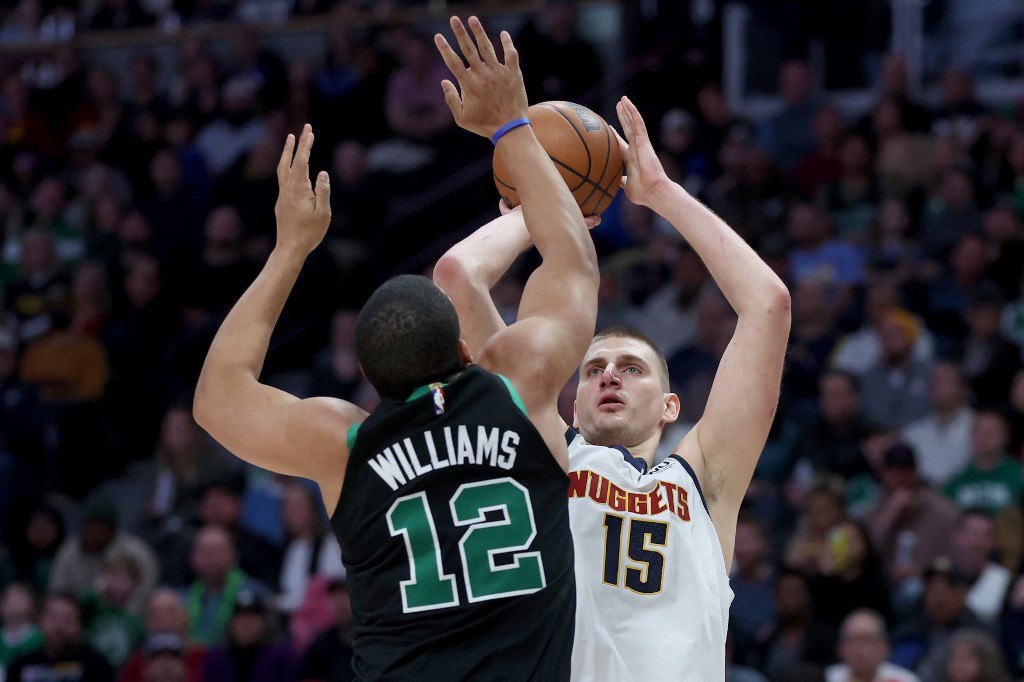 Nikola Jokic #15 of the Denver Nuggets performs a hit with Grant Williams #12 of the Boston Celtics during the 4th round at Ball Arena on January 1, 2023 in Denver, Colorado.