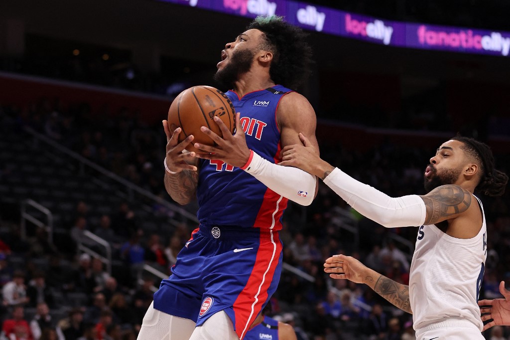 Saddiq Bey #41 of the Detroit Pistons is fouled by D'Angelo Russell #0 of the Minnesota Timberwolves on his way to the basket in the second half at Little Caesars Arena on January 11, 2023 in Detroit, Michigan.