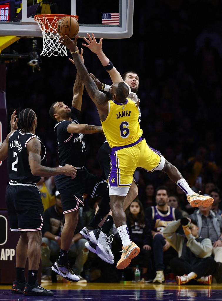LeBron James #6 of the Los Angeles Lakers takes a shot against Norman Powell #24 and Ivica Zubac #40 of the LA Clippers in the second half at Crypto.com Arena on January 24, 2023 in Los Angeles, California. 