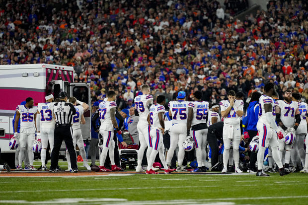Jan 2, 2023; Cincinnati, Ohio, USA; The Buffalo Bills gather as an ambulance parks on the field while CPR is administered to Buffalo Bills safety Damar Hamlin (3) after a play in the first quarter of the NFL Week 17 game between the Cincinnati Bengals and the Buffalo Bills at Paycor Stadium.