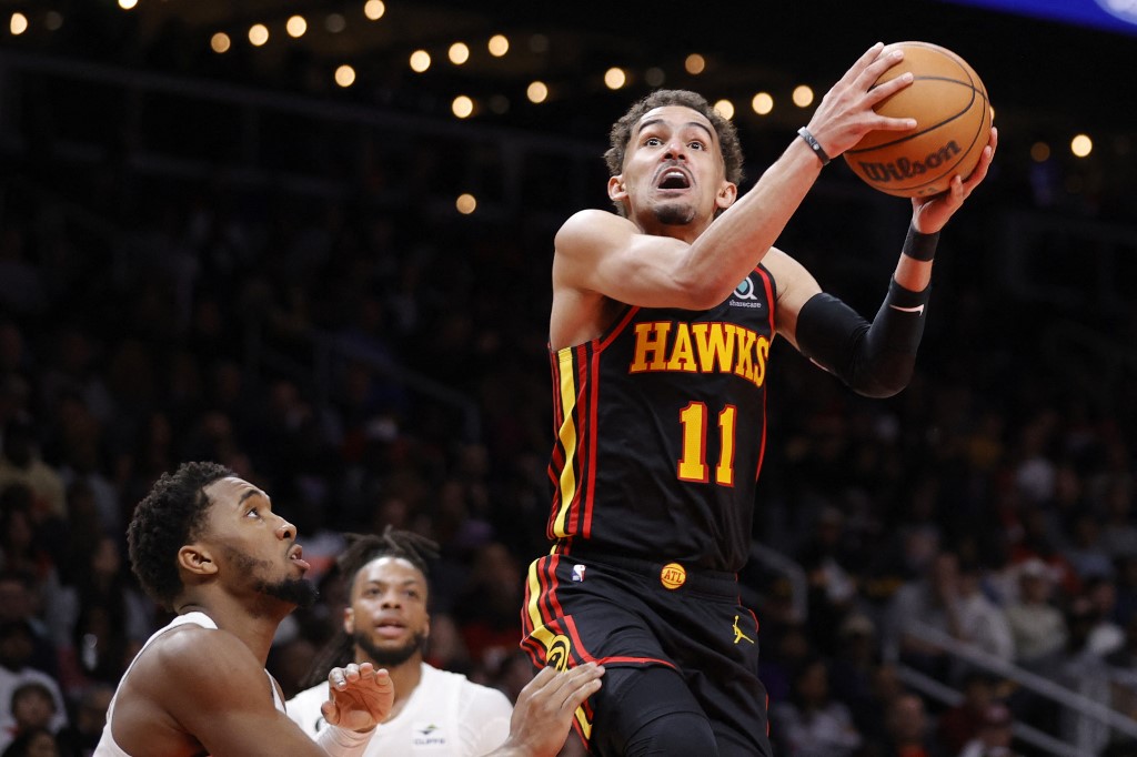Trae Young #11 of the Atlanta Hawks shoots a basket over Donovan Mitchell #45 of the Cleveland Cavaliers during the second half at State Farm Arena on February 24, 2023 in Atlanta, Georgia.