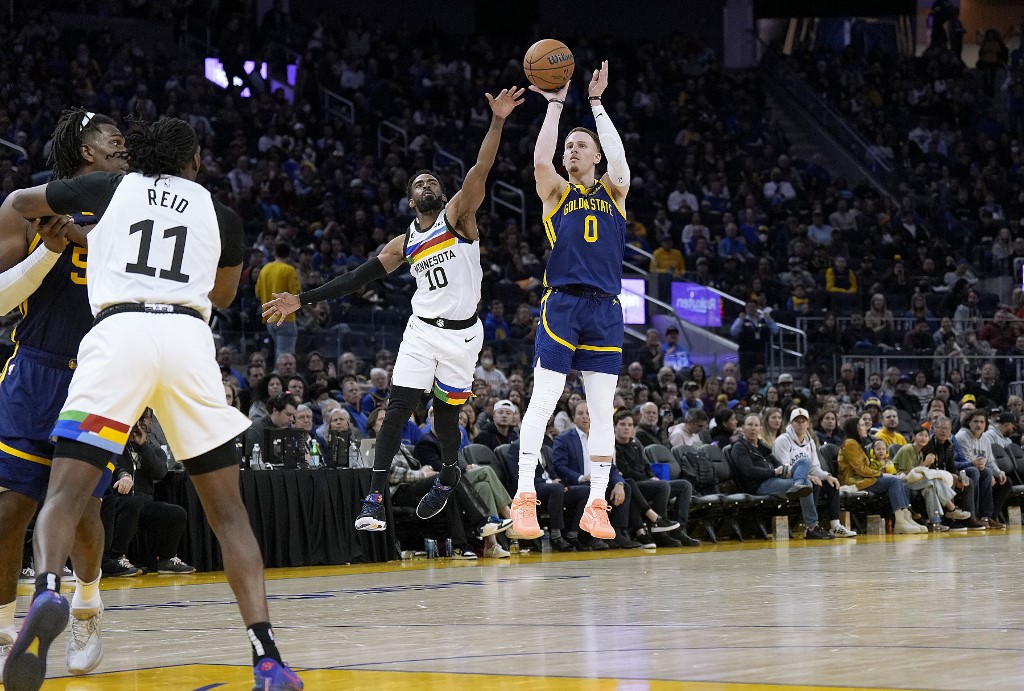  Donte DiVincenzo #0 of the Golden State Warriors shoots in front of Mike Conley #10 of the Minnesota Timberwolves during the third quarter at Chase Center on February 26, 2023 in San Francisco, California.