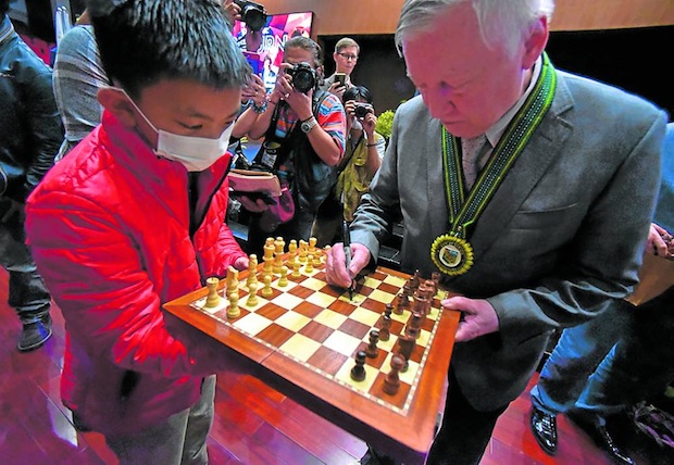 Anatoly Karpov signs a fan's checkerboard.  STORY: Chess icon Karpov recalls the epic battle at Baguio