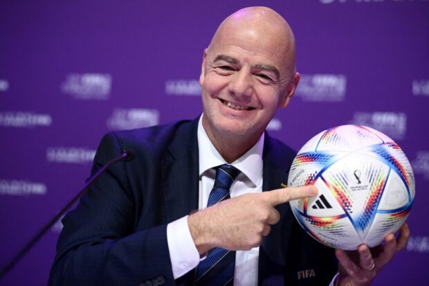 (FILES) This file photo taken on March 31, 2022 shows FIFA president Gianni Infantino posing with Al Rihla, the official match ball before a press conference during the 72nd FIFA Congress in 