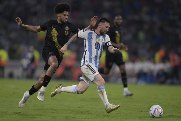 Argentina's forward Lionel Messi (R) is challenged by Curacao's defender Roshon van Eijma during the friendly football match between Argentina and Curacao at the Madre de Ciudades stadium in Santiago del Estero, in northern Argentina, on March 28, 2023. (Photo by JUAN MABROMATA / AFP)