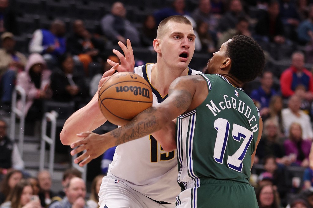  Jokic #15 of the Denver Nuggets tries to make a move around Rodney McGruder #17 of the Detroit Pistons during the first half at Little Caesars Arena on March 16, 2023 in Detroit, Michigan.