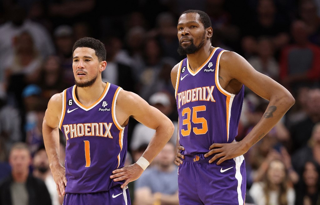 Devin Booker #1 and Kevin Durant #35 of the Phoenix Suns stand on the court during a timeout form the second half of the NBA game against the Minnesota Timberwolves at Footprint Center on March 29, 2023 in Phoenix, Arizona.