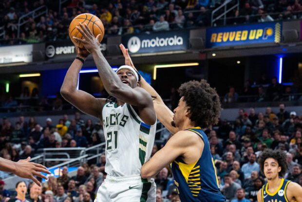 Mar 29, 2023; Indianapolis, Indiana, USA;  Milwaukee Bucks guard Jrue Holiday (21) shoots the ball while Indiana Pacers forward Jordan Nwora (13) defends in the second half at Gainbridge Fieldhouse. Mandatory Credit: Trevor Ruszkowski-USA TODAY Sports