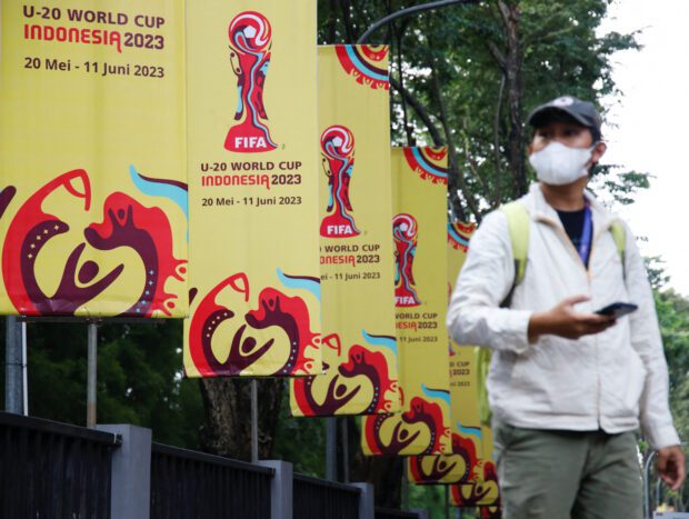 FILE PHOTO: A man walks past FIFA U-20 World Cup banners outside Indonesia's football federation (PSSI) office in Jakarta, Indonesia, March 30, 2023. REUTERS/Willy Kurniawan