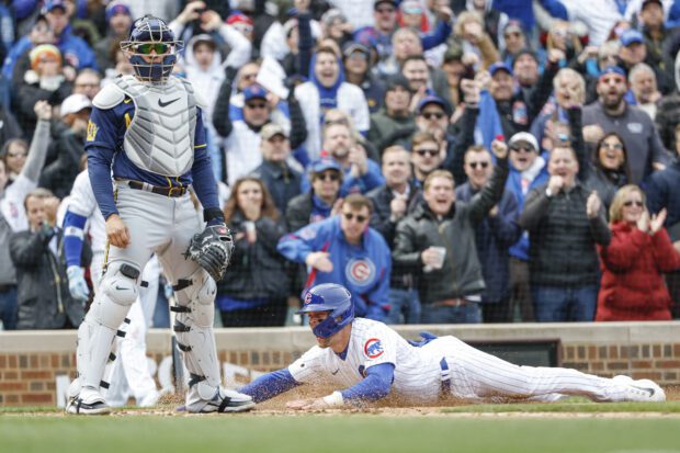 Mar 30, 2023; Chicago, Illinois, USA; Chicago Cubs second baseman Nico Hoerner (2) slides to score against the Milwaukee Brewers during the third inning at Wrigley Field.