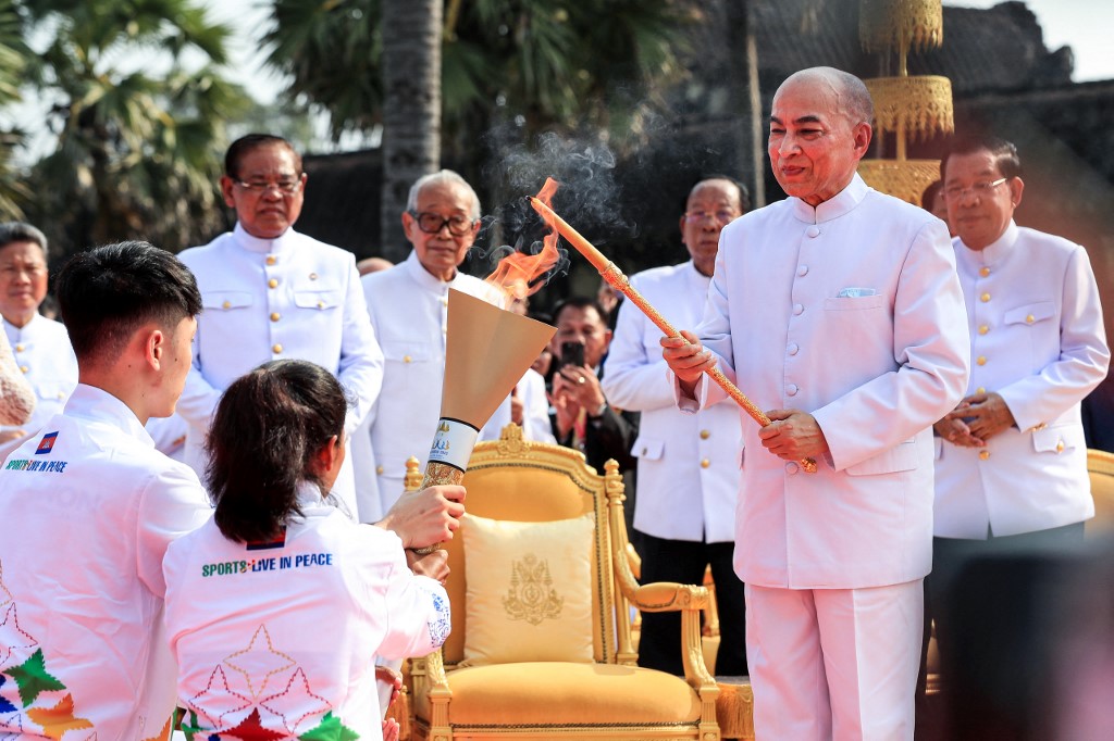 m the sun's rays as Prime Minister Hun Sen (R) looks on during a ceremony prior to the 32nd SEA Games at Angkor Wat temple in Siem Reap province on March 21, 2023