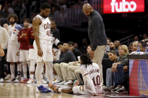 Donovan Mitchell #45 of the Cleveland Cavaliers and J.B. Bickerstaff check on Darius Garland #10 after he fell to the floor while fouling out of the game during the fourth quarter of Game Five of the Eastern Conference First Round Playoffs against the New York Knicks at Rocket Mortgage Fieldhouse on April 26, 2023 in Cleveland, Ohio. 
