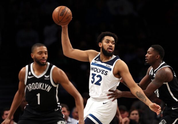 Karl-Anthony Towns #32 of the Minnesota Timberwolves controls the ball as Mikal Bridges #1 and Dorian Finney-Smith #28 of the Brooklyn Nets defend during the game at Barclays Center on April 04, 2023 in New York City. 