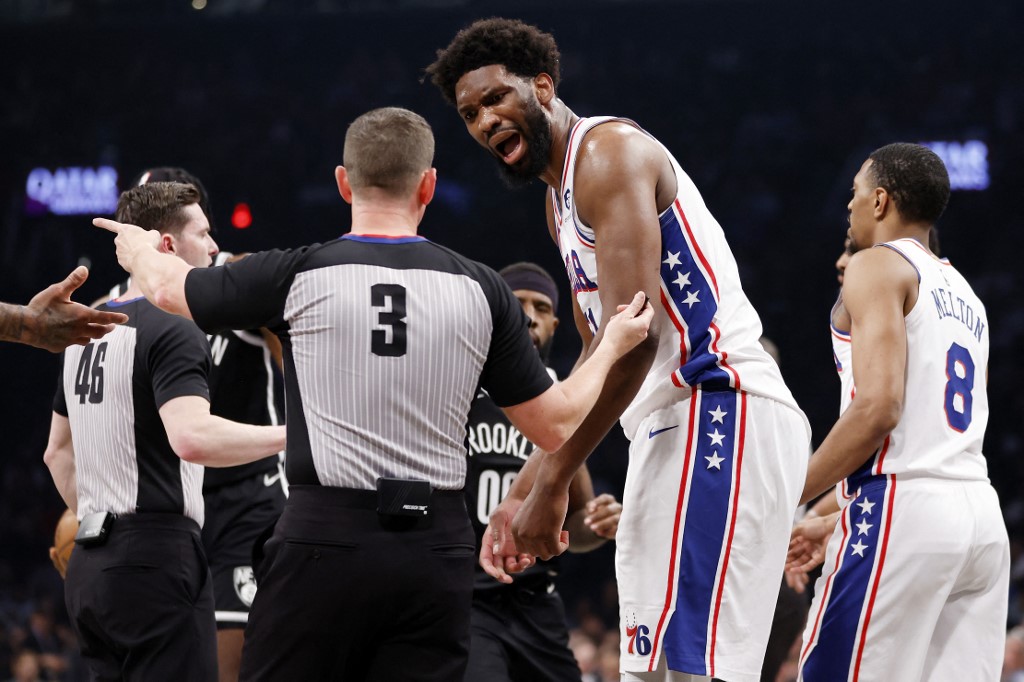 Joel Embiid #21 of the Philadelphia 76ers reacts toward referee Nick Buchert #3 against the Brooklyn Nets during the first half of Game Three of the Eastern Conference First Round Playoffs at Barclays Center on April 20, 2023 in the Brooklyn borough of New York City.