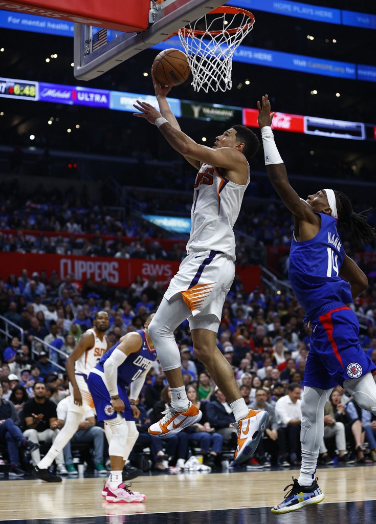 Devin Booker #1 de los Phoenix Suns dispara contra Terance Mann #14 de los LA Clippers en la segunda mitad del tercer juego de los playoffs de la primera ronda de la Conferencia Oeste en Crypto.com Arena el 20 de abril de 2023 en Los Ángeles, California. 