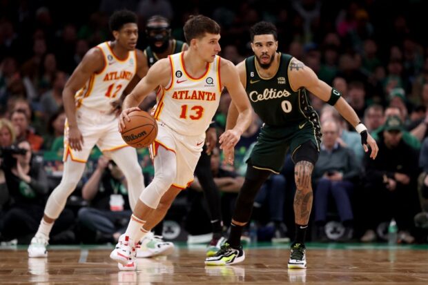   Bogdan Bogdanovic #13 of the Atlanta Hawks dribbles against Jayson Tatum #0 of the Boston Celtics during the third quarterer in game five of the Eastern Conference First Round Playoffs at TD Garden on April 25, 2023 in Boston, Massachusetts.