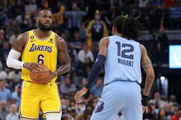 LeBron James #6 of the Los Angeles Lakers handles the ball against Ja Morant #12 of the Memphis Grizzlies during the first half of Game Five of the Western Conference First Round Playoffs at FedExForum on April 26, 2023 in Memphis, Tennessee. 