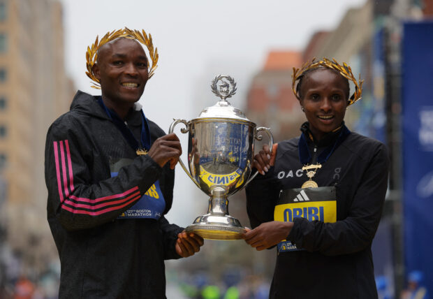 Athletics - The 127th Boston Marathon - Boston, Massachusetts, U.S. - April 17, 2023 Kenya's Evans Chebet and Hellen Obiri pose with the trophy at the finish line after winning the elite men's and elite women's races respectively REUTERS/Brian Snyder