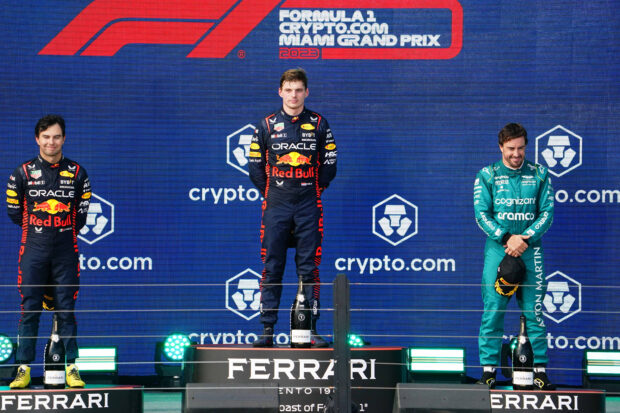 May 7, 2023; Miami Gardens, Florida, USA; Red Bull driver Max Verstappen (1) of the Netherlands, Red Bull driver Sergio Perez (11) of Mexico and Aston Martin driver Fernando Alonso (14) of Spain celebrate on the podium after their finishes in the Miami Grand Prix at Miami International Autodrome.