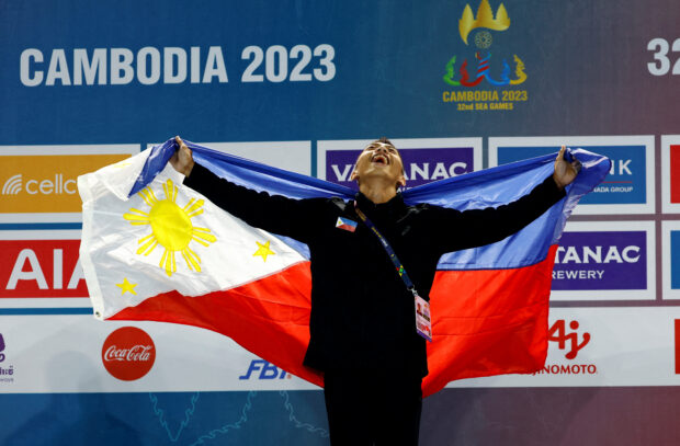 Pesta Olahraga Asia Tenggara - Senam Artistik - Tenda Olimpiade, Phnom Penh, Kamboja - 9 Mei 2023 John Ivan Cruz dari Filipina merayakan kemenangan final latihan lantai putra dengan medali emas di podium