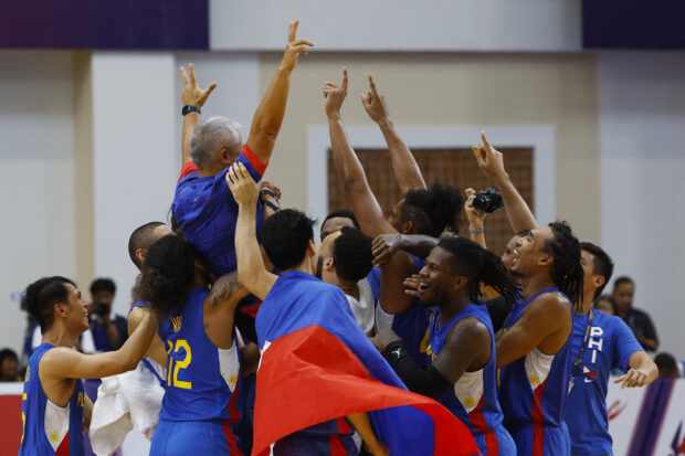 Southeast Asian Games - Basketball - Cambodia v Philippines - Final - Morodok Techo Elephant Hall 2, Phnom Penh, Cambodia - May 16, 2023 Philippines' players celebrate with their coach Reyes Vincet Perez after the team wins the match 