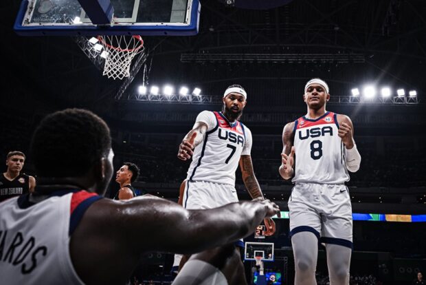 Team USA's Brandon Ingram and Paolo Banchero gestures to help Anthony Edwards in a Fiba World Cup game.