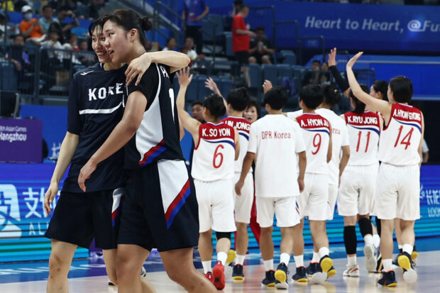 Asian Games - Hangzhou 2022 - Basketball - Hangzhou Olympic Sports Centre Gymnasium, Hangzhou, China - September 29, 2023 South Korean players celebrate while North Korean players wave to the crowd after the match 
