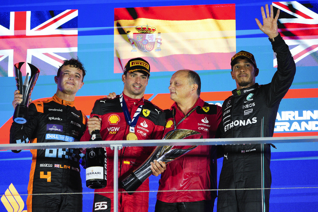Race winner Ferrari driver Carlos Sainz of Spain, second left, stands with second placed McLaren driver Lando Norris of Britain, left, and third placed Mercedes driver Lewis Hamilton of Britain, 