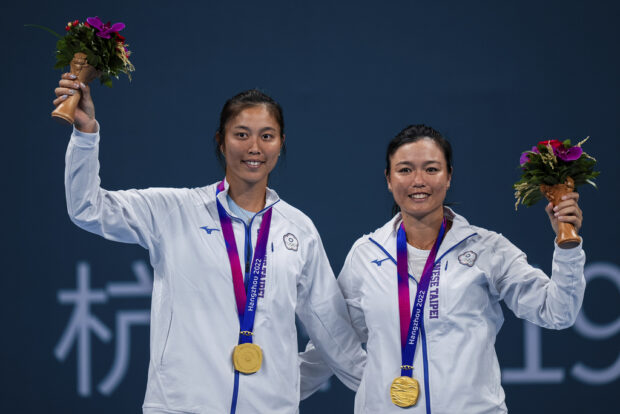 Taiwan's Chan Hao-ching and Chan Yung-jan celebrate with their gold medals after the tennis women's doubles final at the 19th Asian Games in Hangzhou, China, Saturday, Sept. 30, 2023. (