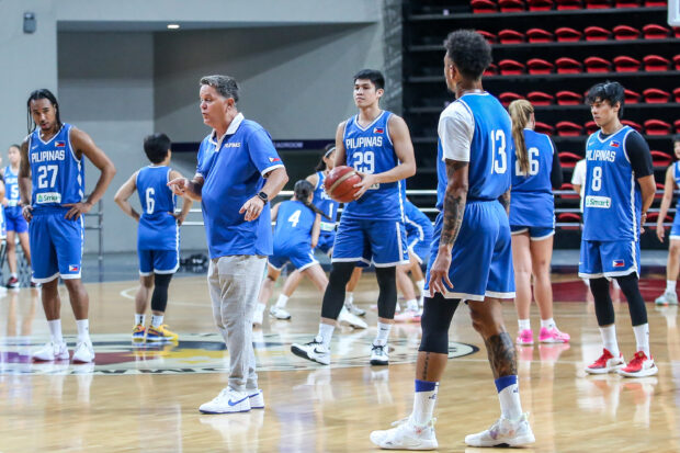 Tim Cone (second from left) gives out pointers to (from left) Chris Newsome, Calvin Oftana, Calvin Abueva and Terrence Romeo while the women’s team trains in the background