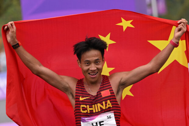 Gold medallst China's He Jie celebrates after the end of the men's marathon final athletics event during the 2022 Asian Games in Hangzhou in China's eastern Zhejiang province on October 5, 2023. 