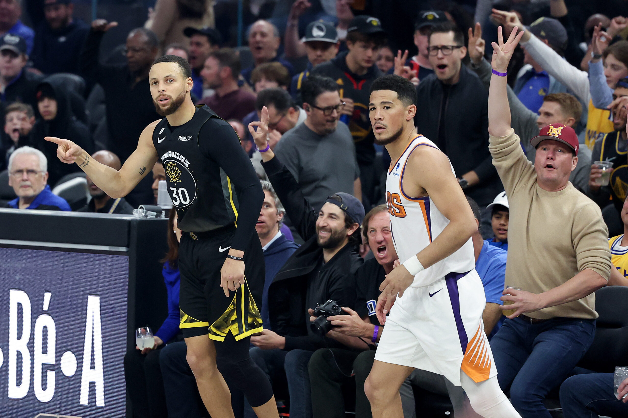 Stephen Curry #30 of the Golden State Warriors reacts after he made a basket on Devin Booker #1 of the Phoenix Suns at Chase Center on March 13, 2023 in San Francisco, California. 