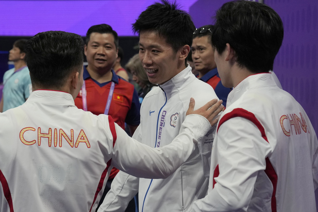 China's Lin Chaopan, at left congratulates Taiwan's Lee Chih Kai after he wins Artistic Gymnastics Men's Pommel Horse Final next to China's Zhang Boheng, at right during the 19th Asian Games in Hangzhou, China, Thursday, Sept. 28, 2023. 