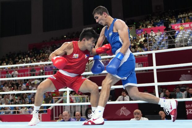 Abdumalik Khalokov of Uzbekistan, right, and Carlo Paalam of Philippines, left, compete during men's 51-57Kg quarterfinal boxing match at the 19th Asian Games in Hangzhou, China, Hangzhou, Tuesday, Oct. 3, 2023. 