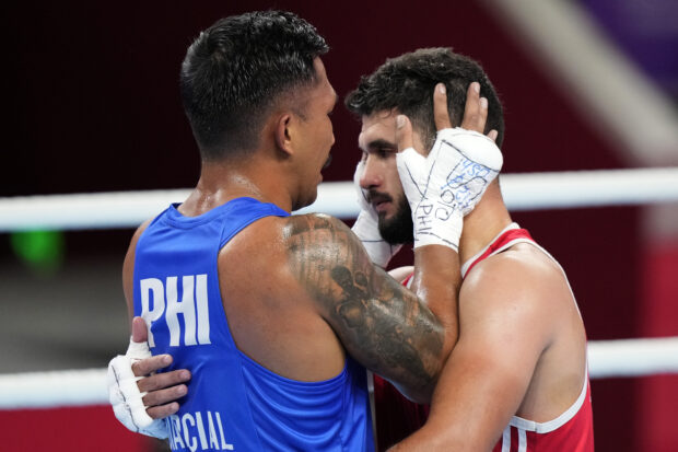 Philippines Eumir Felix Marcial in blue comfort Syria's Ahmad Ghousoon after defeating him in the Boxing Men's 71-80Kg Semifinal bout for the 19th Asian Games in Hangzhou, China, Wednesday, Oct. 4, 2023.