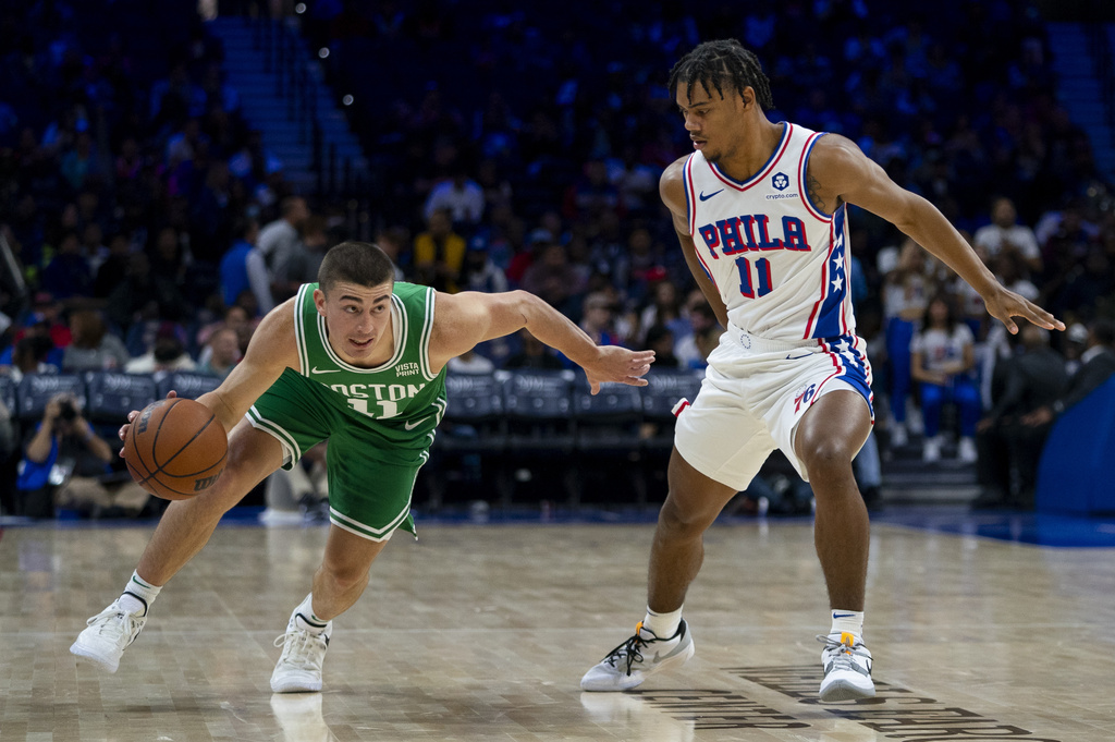 Boston Celtics' Payton Pritchard, left, drives against Philadelphia 76ers' Jaden Springer during the first half of a preseason NBA basketball game Wednesday, Oct. 11, 2023, in Philadelphia
