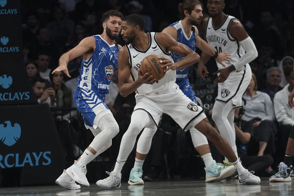 Brooklyn Nets Mikal Bridges, center, holds onto the ball while being defended during a preseason NBA basketball game against Israel's Maccabi Ra'anana, 