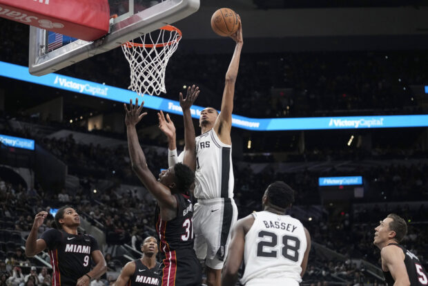 San Antonio Spurs center Victor Wembanyama (1) scores over Miami Heat center Thomas Bryant (31) during the second half of a preseason NBA basketball game in San Antonio,