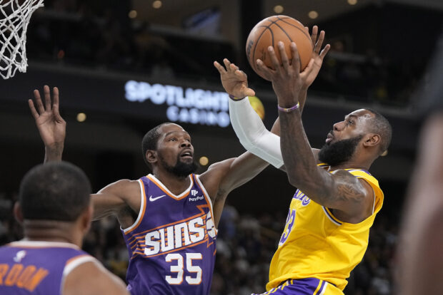 Los Angeles Lakers forward LeBron James, right, shoots as Phoenix Suns forward Kevin Durant defends during the first half of an NBA preseason basketball game Thursday, Oct. 19, 2023, in Thousand Palms, California.