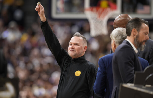 Denver Nuggets coach Michael Malone holds up his NBA championship ring during a ceremony before the team's NBA basketball game against the Los Angeles Lakers on Tuesday, Oct. 24, 2023, in Denver. 