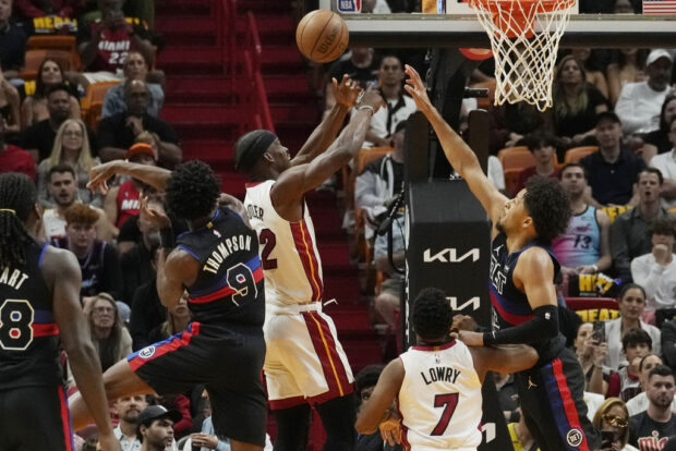 Detroit Pistons forward Ausar Thompson (9) swipes the ball away from Miami Heat forward Jimmy Butler (22) during the first half of an NBA basketball game, Wednesday, Oct. 25, 2023, in Miami.