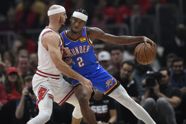 Oklahoma City Thunder's Shai Gilgeous-Alexander (2) looks to drive against Chicago Bulls' Alex Caruso, left, during the second half of an NBA basketball game Wednesday, Oct. 25, 2023, in Chicago.